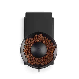 Overhead view of the Fellow Opus coffee grinder with a black finish with coffee in the hopper.