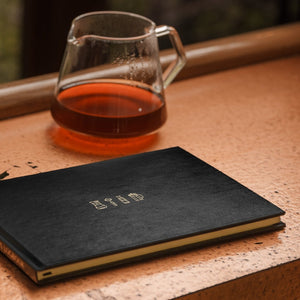 Coffee Brewer's Logbook with a pitcher of coffee on a table.