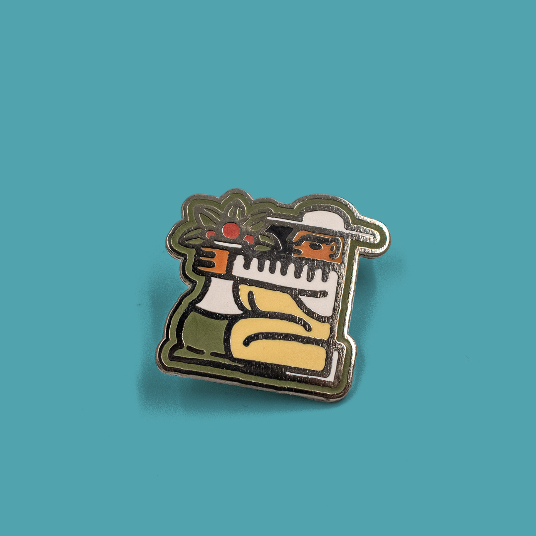 Detailed closeup of enamel pin depicting a coffee farmer.