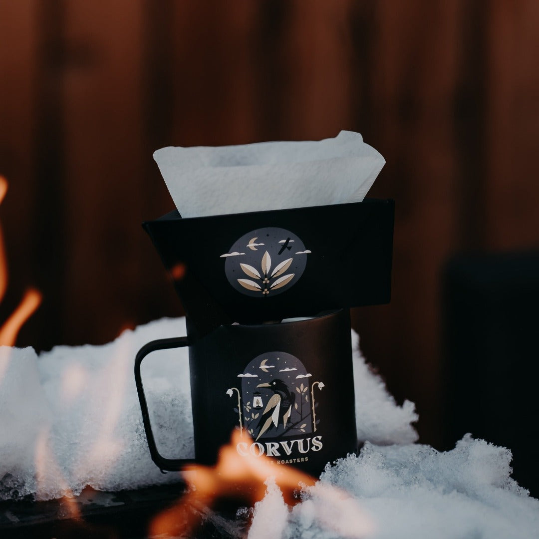 MiiR Pourigami over MiiR coffee cup in snow around campfire,