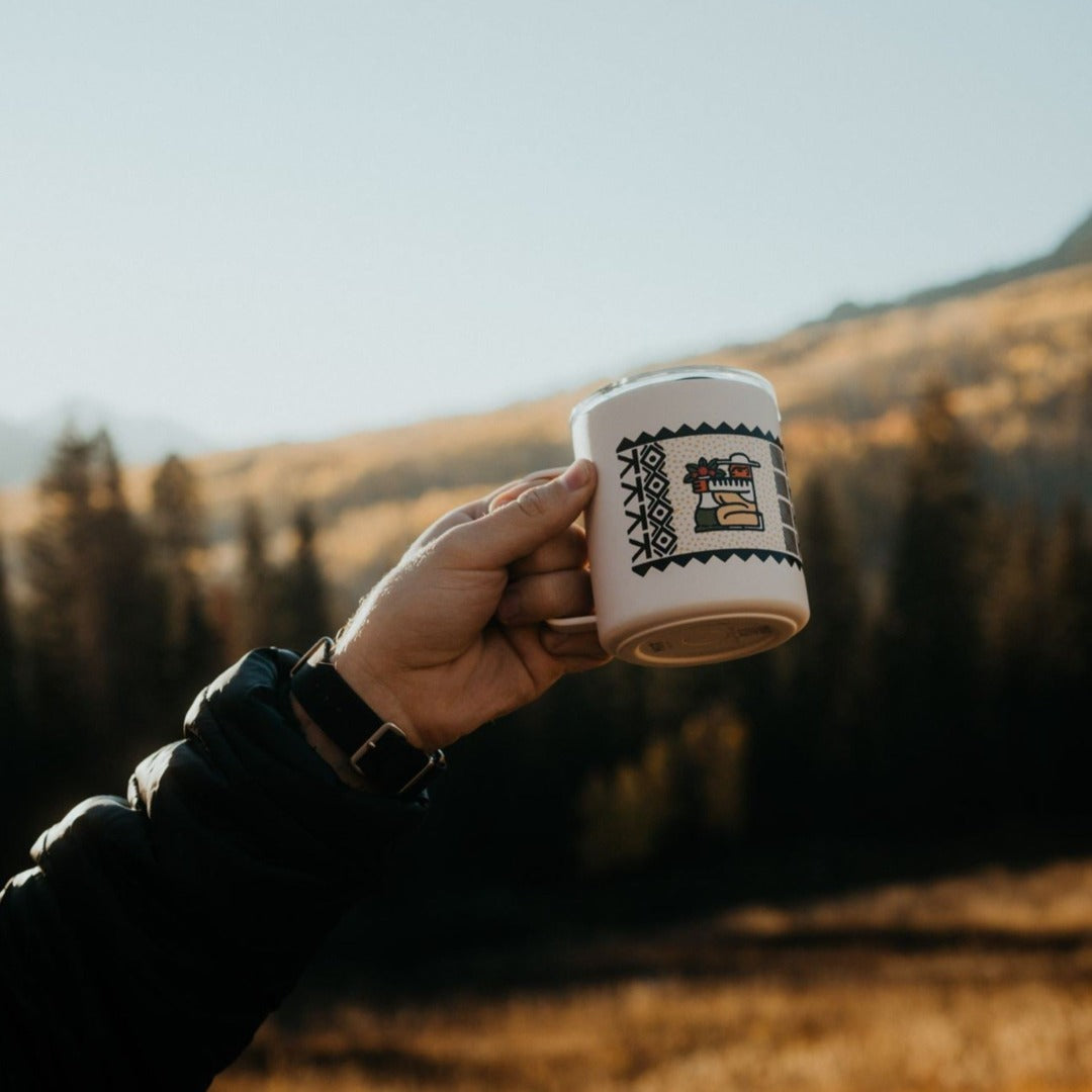 Specialty Coffee Roasters Camp Mug designed by Zaine Vaun depicting a coffee farmer being held up outside in a mountain setting.